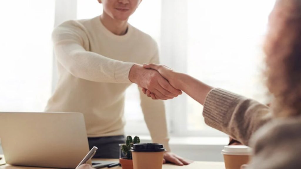 A venture capitalist shaking a startup founder’s hand.