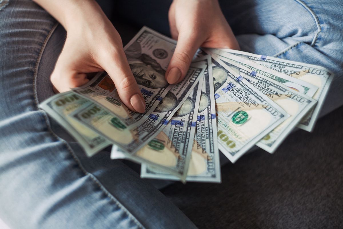A woman holding $100 bills