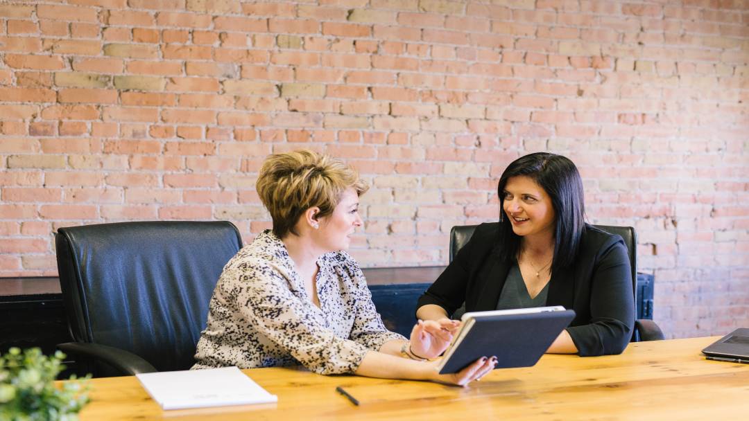 Two women discussing something at a table