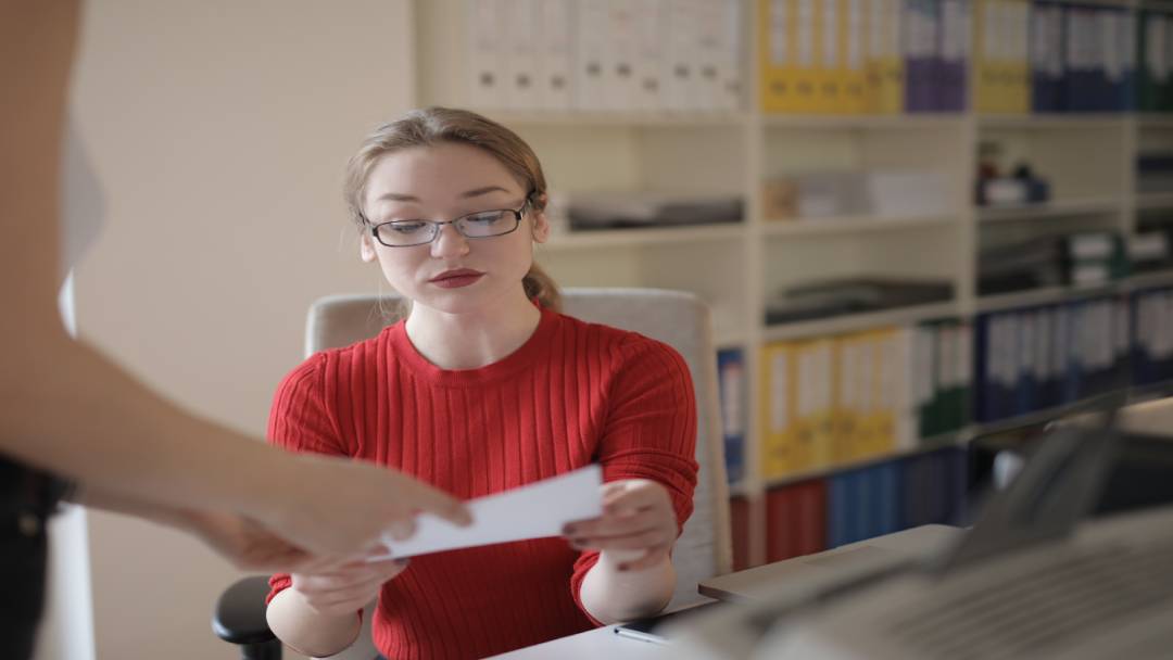 Woman taking a document from another woman