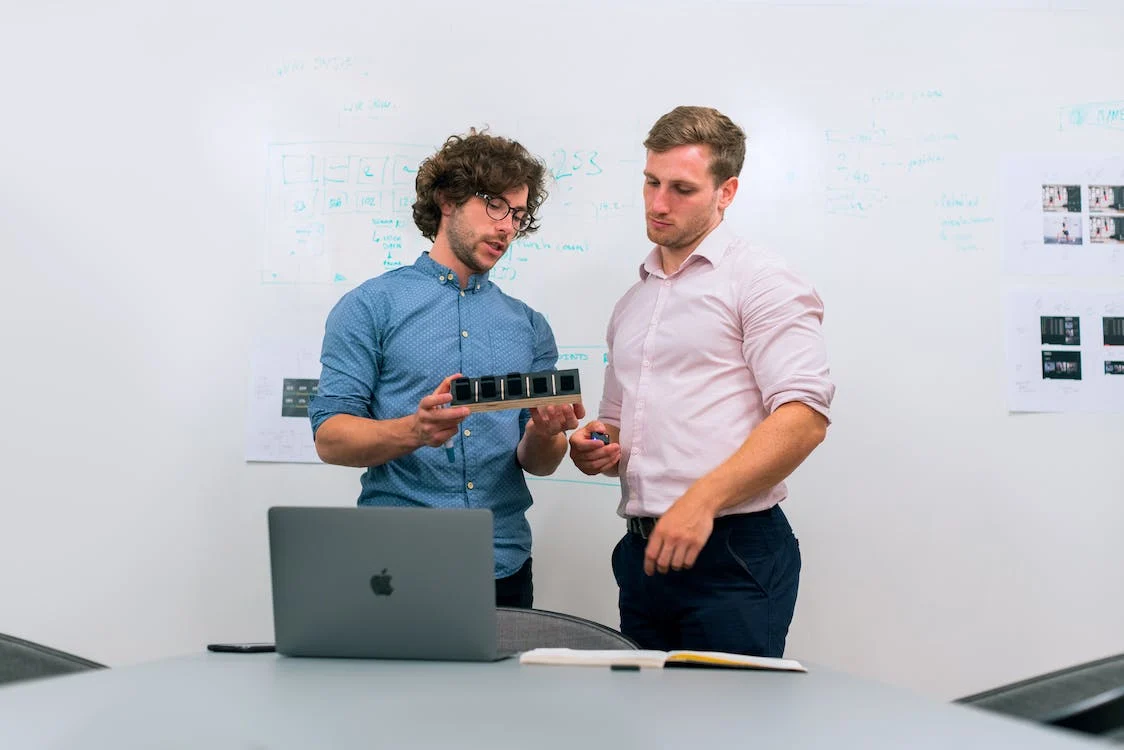 Two men looking at a model in an office
