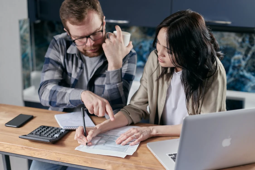 Two small business owners calculating their liabilities