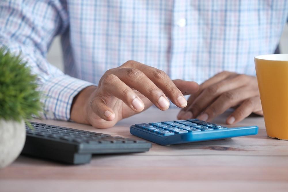 A man using a calculator to determine his R&D credit refund
